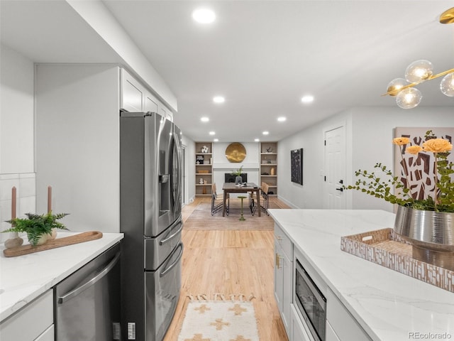 kitchen featuring light stone counters, recessed lighting, appliances with stainless steel finishes, and white cabinets