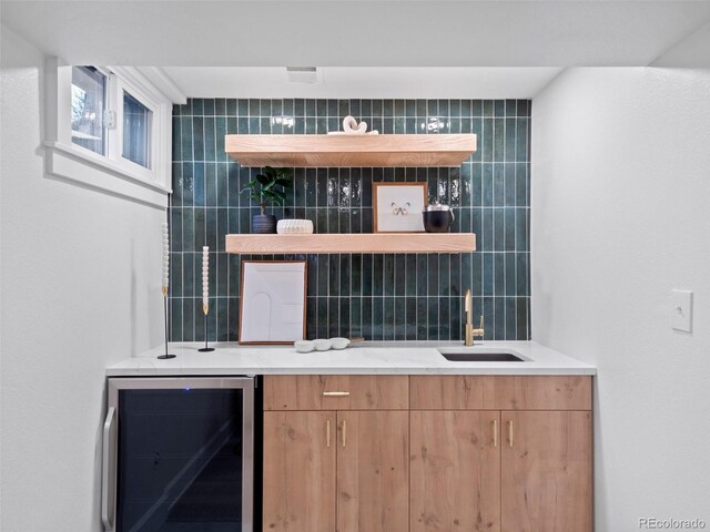 bar featuring decorative backsplash, tile walls, wine cooler, and a sink