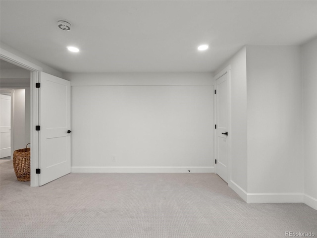 basement with light carpet, recessed lighting, and baseboards