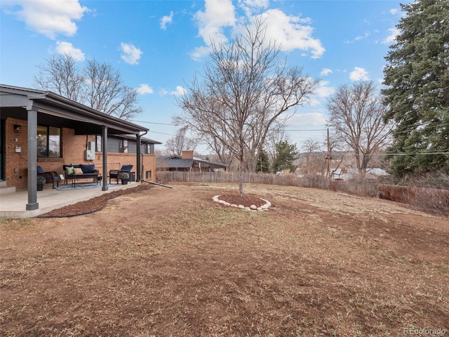 view of yard with fence, outdoor lounge area, and a patio area