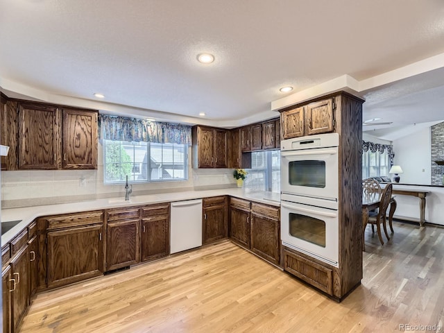 15035 E Grand Ave, Aurora, CO 80015 - kitchen with double oven, dishwasher, light wood-style flooring, tasteful backsplash, and recessed lighting