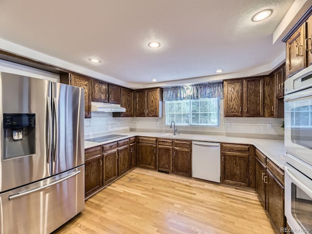 15035 E Grand Ave, Aurora, CO 80015 - kitchen featuring stainless steel fridge, dishwashing machine, under cabinet range hood, light countertops, and decorative backsplash