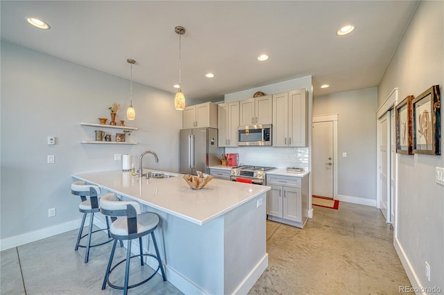 kitchen with open shelves, stainless steel appliances, decorative backsplash, a sink, and a kitchen bar