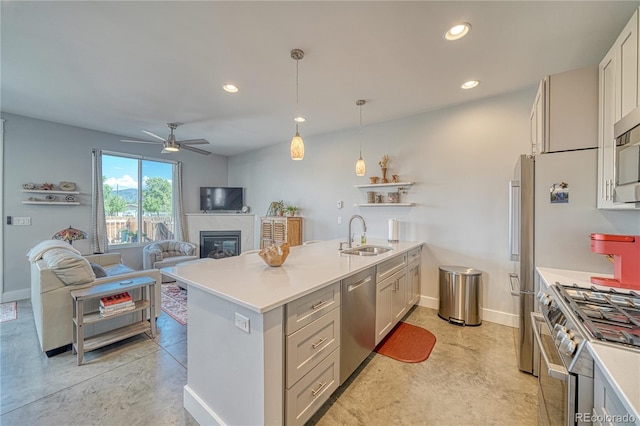 kitchen with stainless steel appliances, recessed lighting, light countertops, a sink, and a peninsula