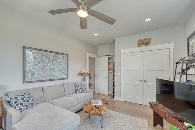 living room featuring recessed lighting, baseboards, ceiling fan, and light wood finished floors