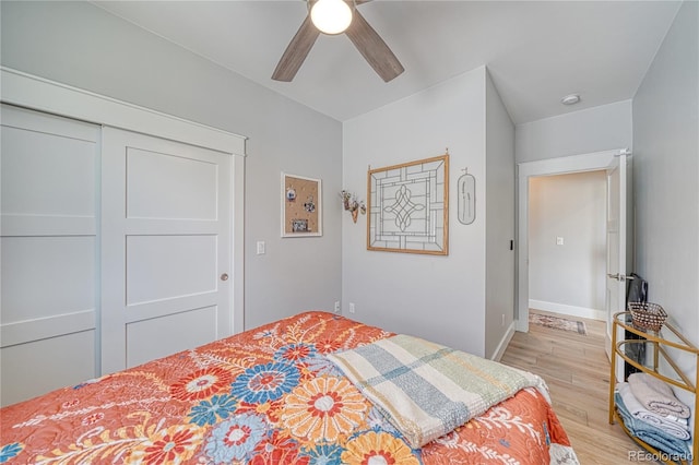 bedroom featuring ceiling fan, light wood finished floors, a closet, and baseboards