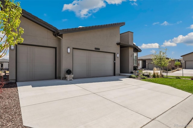 3251 Virga Loop, Colorado Springs, CO 80904 - view of front facade featuring an attached garage, concrete driveway, and stucco siding