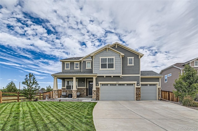 craftsman-style home featuring concrete driveway, a front lawn, and fence