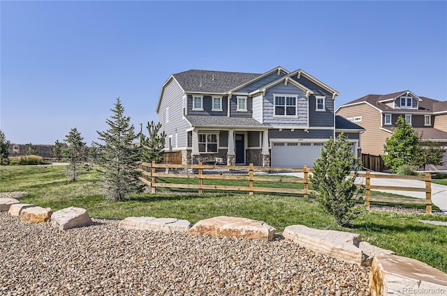 view of front facade featuring an attached garage, stone siding, and a fenced front yard