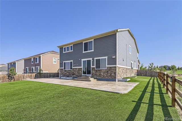 rear view of house featuring stone siding, a yard, a patio, and entry steps