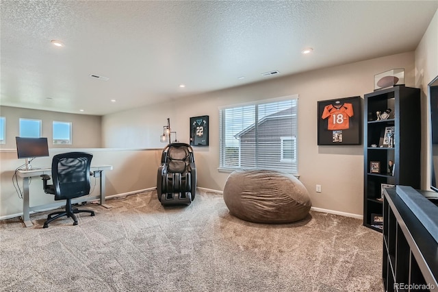 carpeted office space featuring visible vents, a wealth of natural light, and a textured ceiling