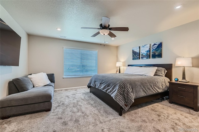 bedroom featuring visible vents, baseboards, ceiling fan, light carpet, and a textured ceiling