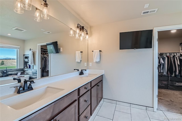 full bath featuring tile patterned flooring, visible vents, double vanity, and a sink