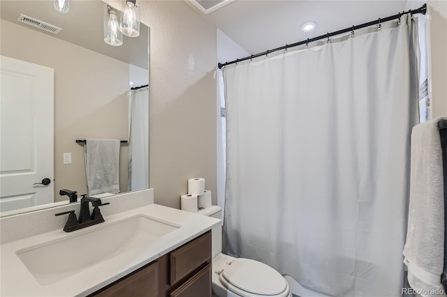 bathroom featuring visible vents, toilet, and vanity