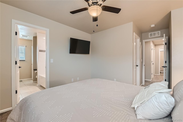 bedroom with visible vents, light colored carpet, ensuite bath, and baseboards