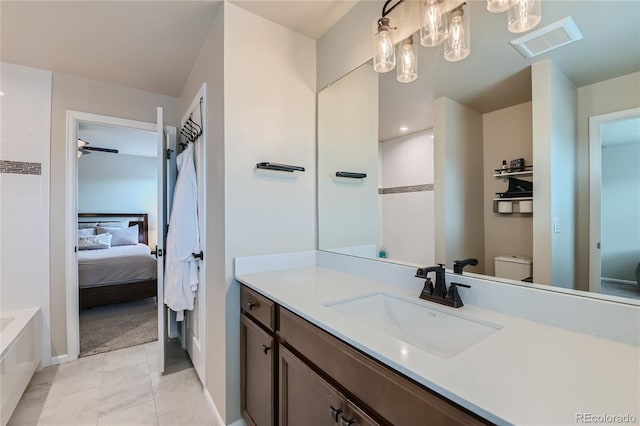 ensuite bathroom with visible vents, toilet, a bathing tub, connected bathroom, and vanity