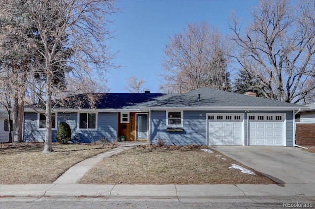 ranch-style house with a garage, driveway, and a chimney