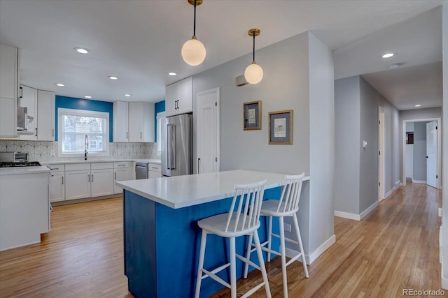 kitchen with tasteful backsplash, appliances with stainless steel finishes, a breakfast bar, and a sink