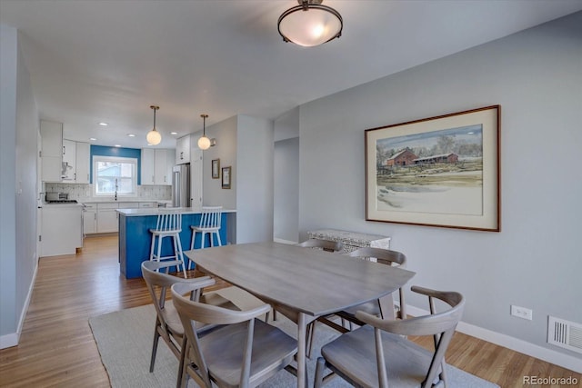 dining area featuring light wood-style floors, recessed lighting, visible vents, and baseboards