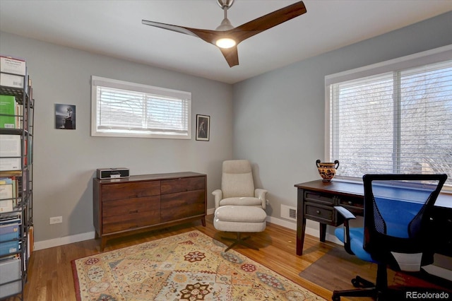 home office featuring wood finished floors, visible vents, and baseboards