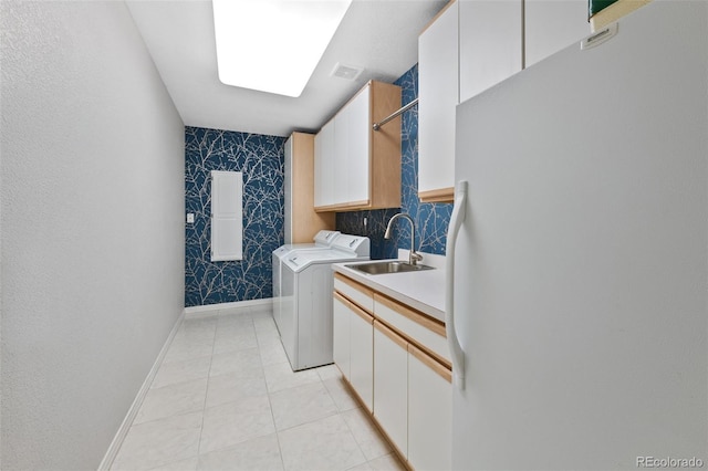 washroom with cabinet space, visible vents, washing machine and dryer, a sink, and light tile patterned flooring