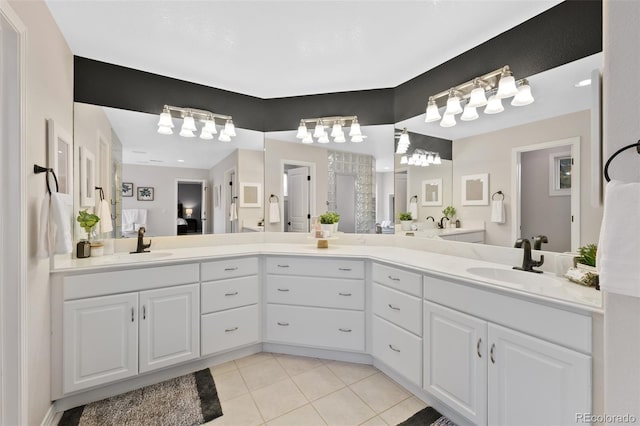 ensuite bathroom featuring tile patterned flooring, tiled shower, a sink, and double vanity