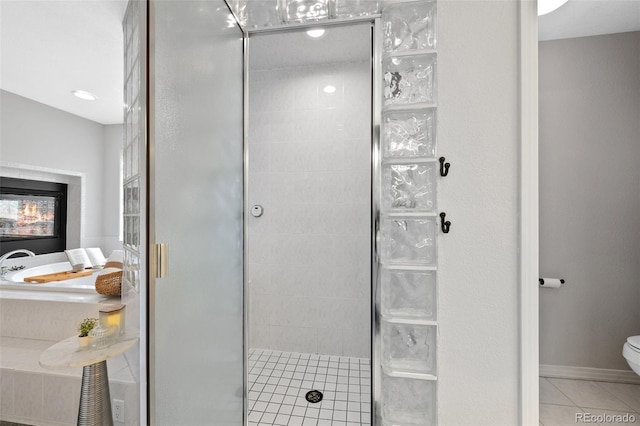 bathroom with toilet, baseboards, a shower stall, a bath, and tile patterned floors