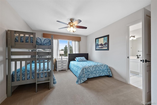 carpeted bedroom with a ceiling fan, baseboards, a sink, and ensuite bathroom