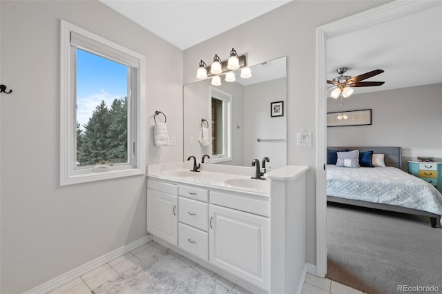 full bath featuring double vanity, a sink, a ceiling fan, and baseboards