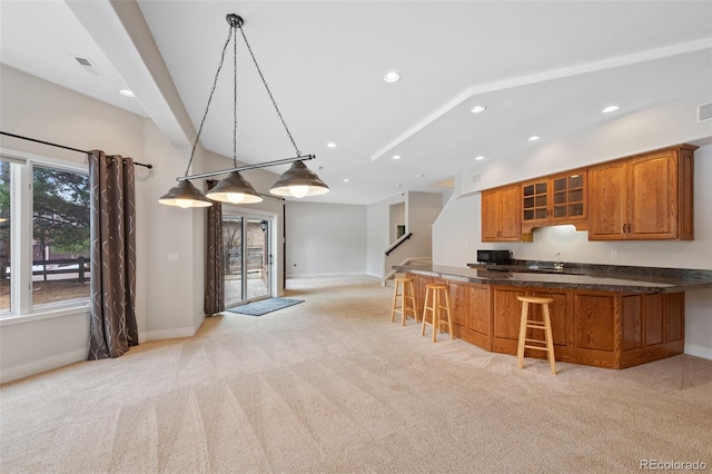 kitchen with baseboards, glass insert cabinets, a breakfast bar area, brown cabinets, and recessed lighting