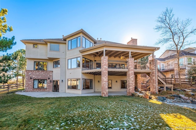 back of property featuring a lawn, ceiling fan, a chimney, fence, and a patio area