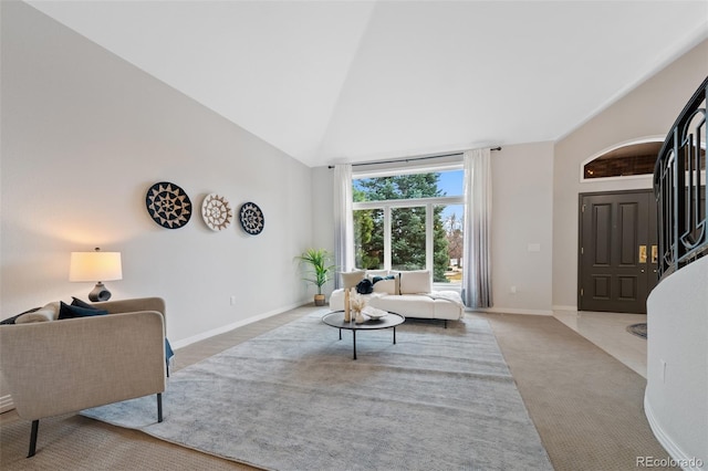 carpeted living room featuring baseboards and high vaulted ceiling