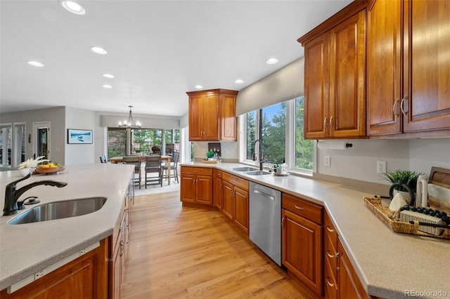 kitchen with brown cabinetry, light countertops, dishwasher, and a sink