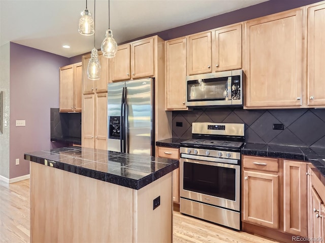 kitchen with stainless steel appliances, tile counters, decorative backsplash, light brown cabinetry, and light wood-type flooring