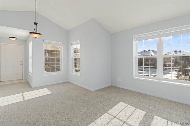 spare room featuring light colored carpet and vaulted ceiling