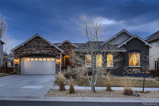 single story home featuring a garage, stone siding, and concrete driveway