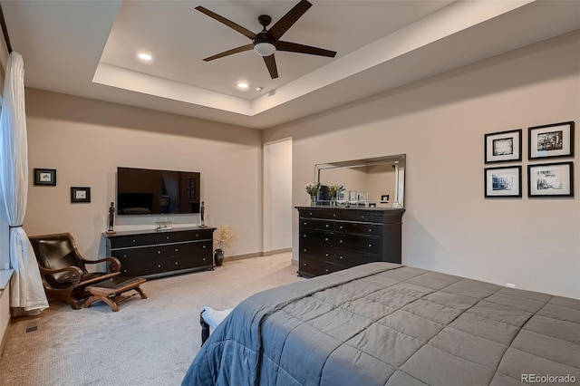 carpeted bedroom with a raised ceiling, a ceiling fan, and recessed lighting