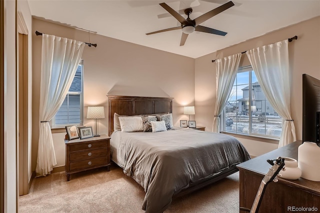 bedroom with a ceiling fan and light colored carpet