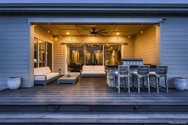 wooden terrace with ceiling fan and an outdoor living space