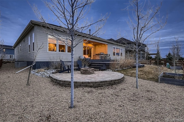 rear view of property featuring an outdoor fire pit and a patio area