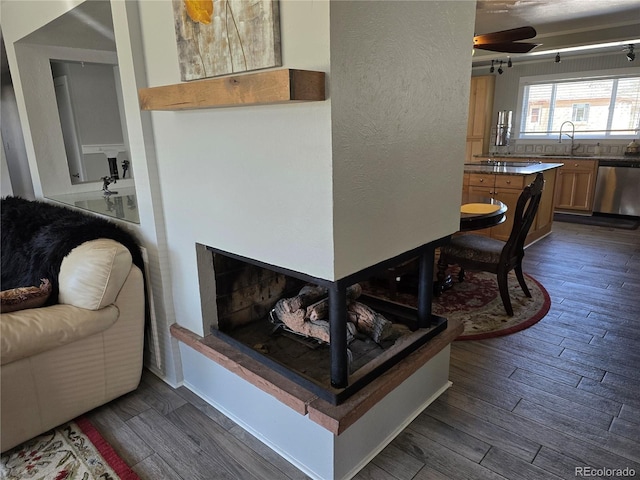 interior space with a fireplace with raised hearth, dark wood-type flooring, and a textured wall