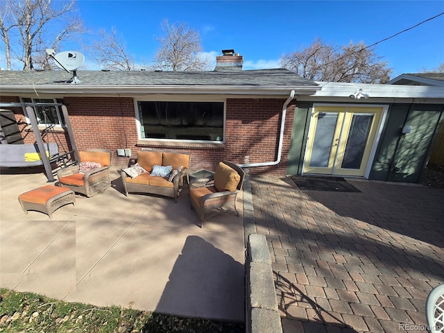 exterior space featuring french doors, an outdoor hangout area, brick siding, a chimney, and a patio area