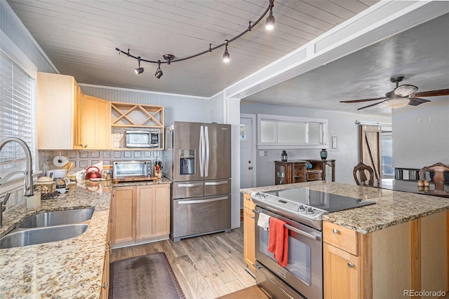 kitchen featuring a sink, stainless steel appliances, light brown cabinets, and light wood finished floors