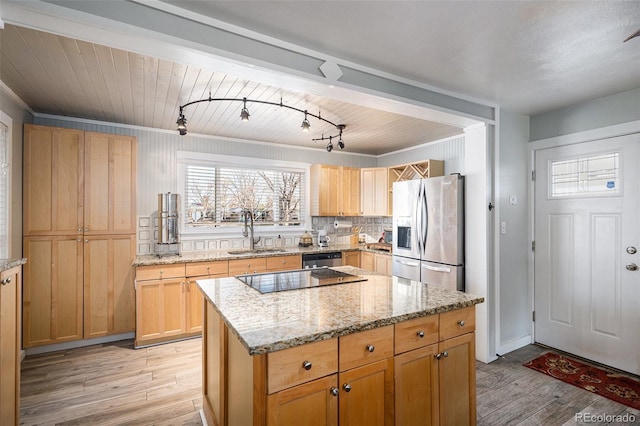 kitchen featuring a sink, stainless steel appliances, light wood-type flooring, and a kitchen island