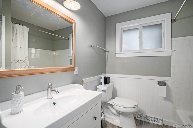 bathroom featuring vanity, toilet, visible vents, and a wainscoted wall