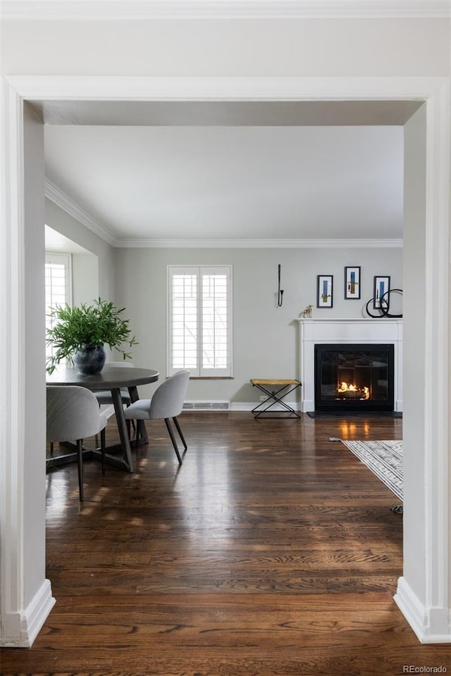 dining room with dark wood-type flooring and ornamental molding