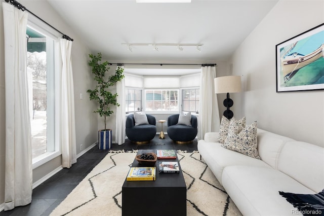 tiled living room with a healthy amount of sunlight and track lighting