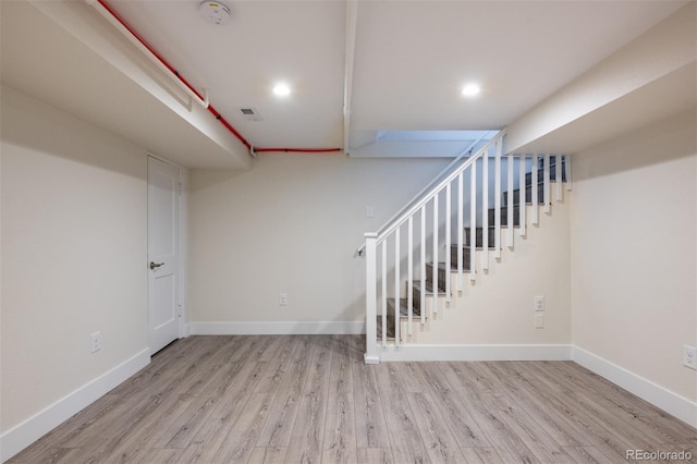 basement with light hardwood / wood-style flooring