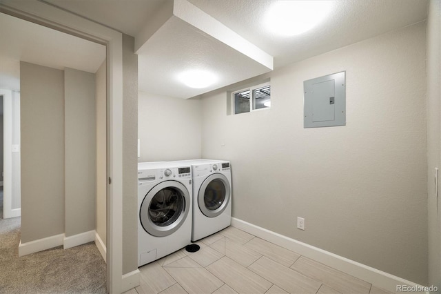 laundry area with washing machine and dryer, a textured ceiling, and electric panel