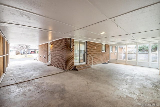 interior space with concrete flooring and brick wall